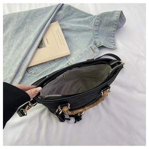 Top view of bucket bag interior showing grey lining, metal zipper and bamboo handle