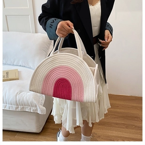Close-up of a crescent cotton rope woven bag with pink gradient rainbow arch patterns