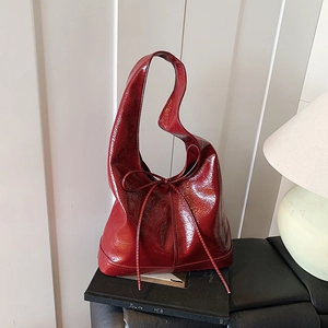 Elegant reddish brown faux leather shoulder bag with chic bow detail and glossy finish