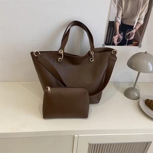Ensemble sac seau rétro marron et pochette avec anneaux dorés dans un décor intérieur