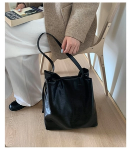 Detail of the soft black synthetic leather texture and drape on this large tote bag