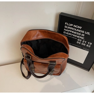 Détail du sac vintage marron montrant l'intérieur spacieux et la fermeture éclair fluide
