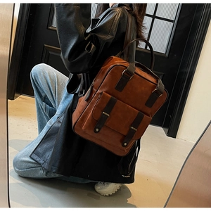 Vue détaillée d'un sac à dos vintage marron foncé avec boucles en métal et rabat