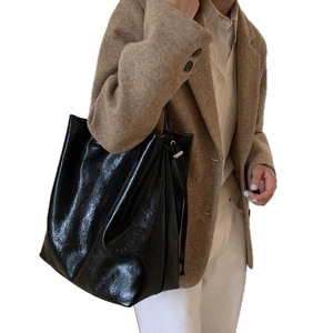 Large capacity black glossy leather tote bag with drawstring details and wide shoulder strap