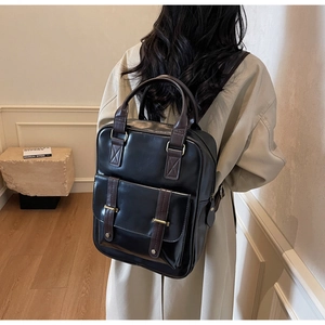Détails d'un sac à dos vintage en similicuir porté par un mannequin en décor épuré