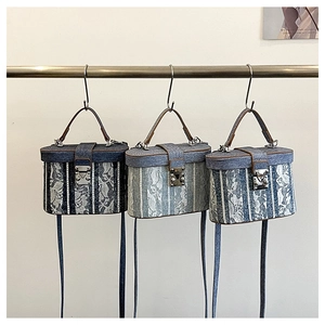 Dettaglio di borse in denim con applicazioni in pizzo bianco e rifiniture in cuoio