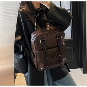 Détails d'un sac à dos vintage en similicuir marron foncé avec boucle en métal et poignée