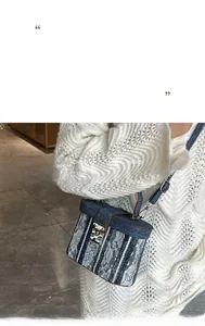 Dettaglio della borsa a tracolla in denim blu e pizzo bianco con chiusura vintage in metallo
