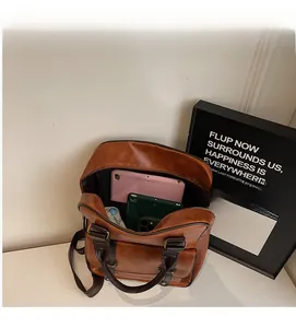 Vue de dessus de l'intérieur spacieux du sac en cuir marron avec tablette et téléphone