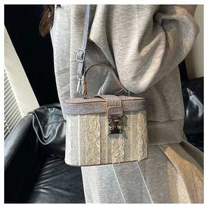 Dettaglio della borsa a scatola in denim blu e pizzo bianco con chiusura in metallo