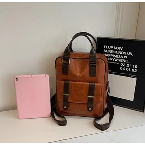 Détail d'un sac à dos vintage en cuir PU marron avec boucle magnétique et bretelles chic