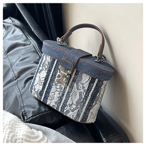 Dettaglio della borsa in denim blu e pizzo bianco con chiusura in metallo argentato
