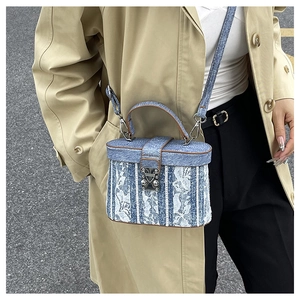 Dettaglio mini borsa a scatola in denim blu con ricami in pizzo bianco e chiusura