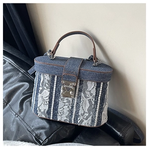 Macro detail of denim and lace patchwork on a mini bucket bag with leather trim