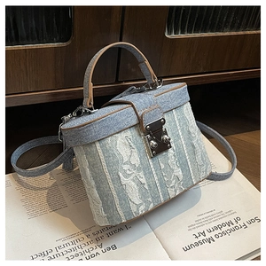Dettaglio della borsa a scatola in denim azzurro con finiture in pelle e chiusura in argento