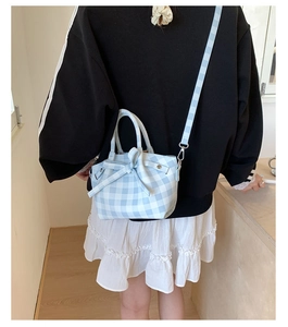 Détail du sac à bandoulière vichy bleu clair avec nœud porté par un mannequin de dos