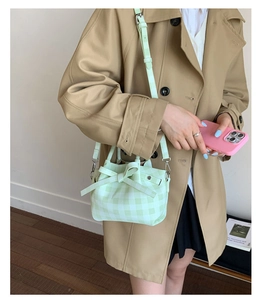 Détail du sac seau à carreaux vert menthe avec un grand nœud sur la bandoulière