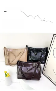 Three minimalist tote bags in black, khaki, and brown with metallic eyelet strap details