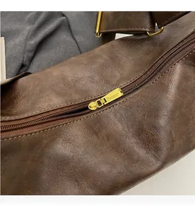 Close-up of smooth gold metal zipper and vintage brown leather texture on bucket bag