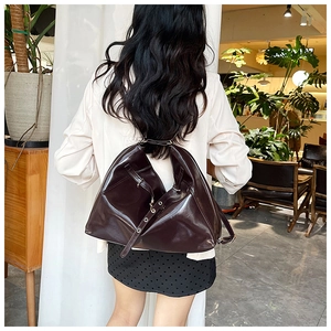 Close-up of a dark brown glossy leather tote bag showing smooth texture and large capacity