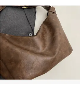 Close-up of vintage dark brown bucket bag showing soft pleated faux leather texture