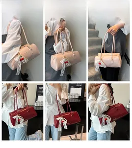 Détail du sac bandoulière cylindrique avec nœud en dentelle et pendentif cerise élégant