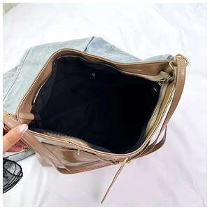 Top view of spacious brown tote bag interior featuring a black lining and zip pocket
