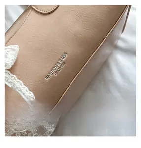 Vue détaillée du sac en cuir beige avec texture plissée et bordure en dentelle blanche