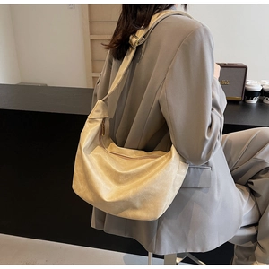 Detail of soft cream white hobo bag with natural leather folds and adjustable strap