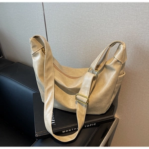 Detail of soft beige hobo bag with adjustable strap and premium gold zipper hardware