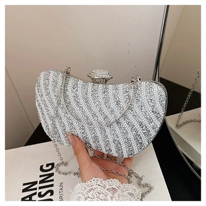 Dettaglio della pochette da sera bianca a mezzaluna con perle e strass diagonali