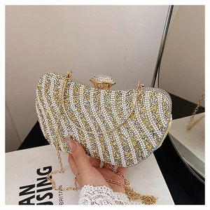 Dettaglio della pochette da sera con perle bianche, paillettes dorate e chiusura a diamante