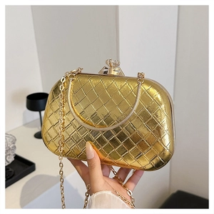Detail of gold metal clutch with leather weave pattern and luxury rhinestone clasp
