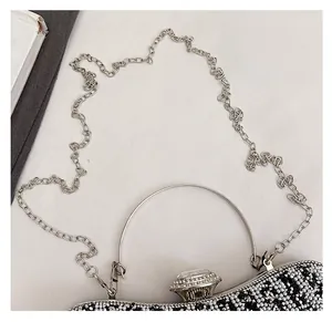 Dettaglio borsa da sera argento con perle finte e chiusura con gemma preziosa