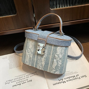 Borsa a scatola in denim blu con ricami in pizzo bianco e rifiniture in pelle marrone
