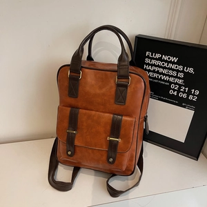 Sac à dos rétro en similicuir marron avec boucles dorées et poignée contrastée, décor minimaliste