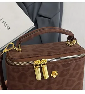 Detailed close-up of leopard print mini box bag with golden floral accents and metal zipper
