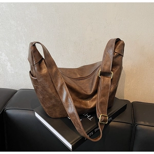 Detailed close-up of dark brown hobo bag with vintage leather texture and metal buckle