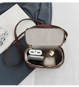 Leopard print crossbody bag interior showing phone, lipstick and essential item capacity