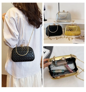 Quilted clutch bag with metal ring handle and chain strap showing internal storage space