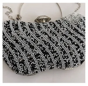 Dettaglio di borsa da sera con strass a zigzag e manico ad anello in argento