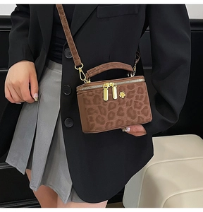 Detailed shot of mini leopard print box bag with gold floral zipper pulls and strap