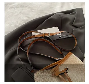 Detail view of woven bucket bag with brown leather drawstring on a gray blazer