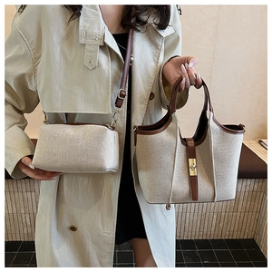 Beige canvas and brown leather tote set featuring a golden turn-lock closure on large bag