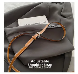 Close-up of adjustable leather shoulder strap with silver buckle on canvas bucket bag