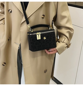 Detailed close-up of a leopard print box bag with gold floral hardware and a thin strap