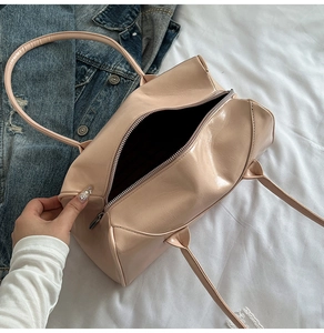 Détail d'un sac Boston en similicuir verni beige avec fermeture éclair et anses