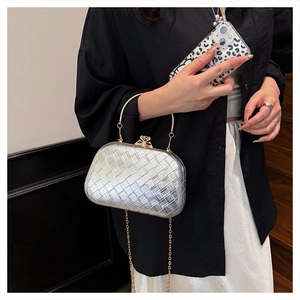Close-up of silver woven clutch bag with gold ring handle and sparkling rhinestone clasp