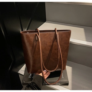 Detailed view of dark brown vintage tote bag with waxed leather texture and dual shoulder straps