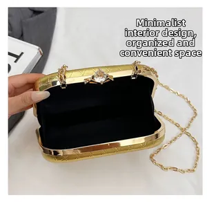 Detail of evening bag interior with gold frame, crystal clasp and sleek black lining